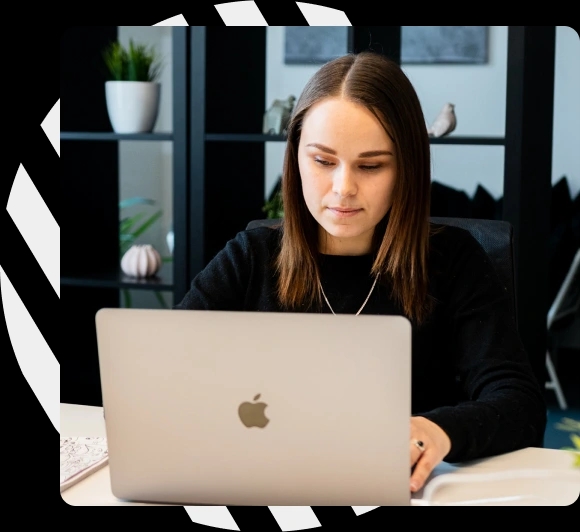 Person sitting in front of an MacBook in an office, engaged in quality assurance work.