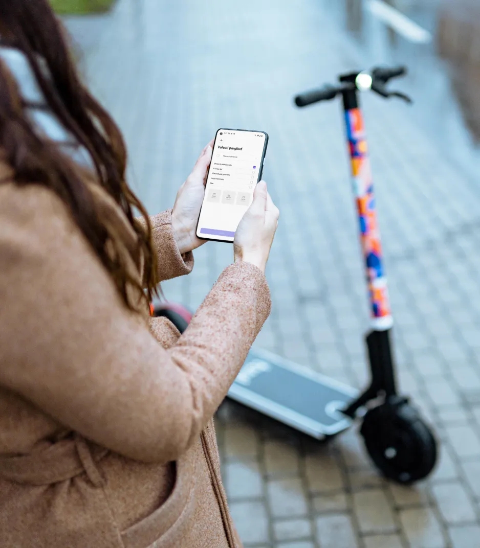 Woman using a mobile app to access an electric scooter.