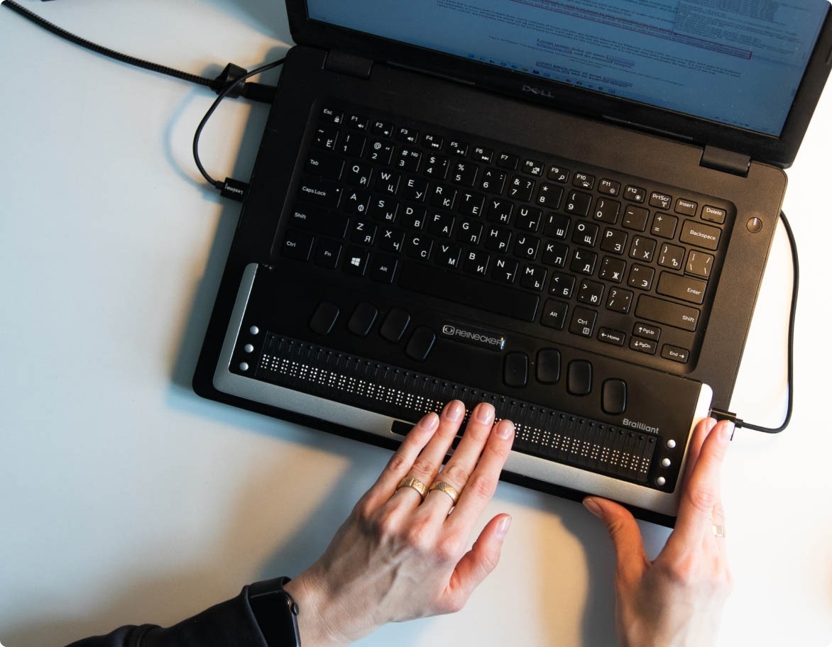 Accessibility testing services in action; a person using a Braille keyboard.
