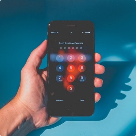 Close-up of hand holding a mobile phone with an authentication feature.