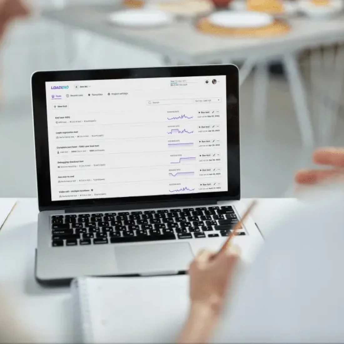 Una persona trabajando en un portátil, revisando datos y gráficos mostrados en la pantalla.