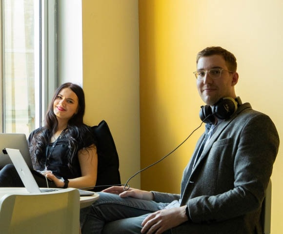 Software engineers sitting at desk and smiling.