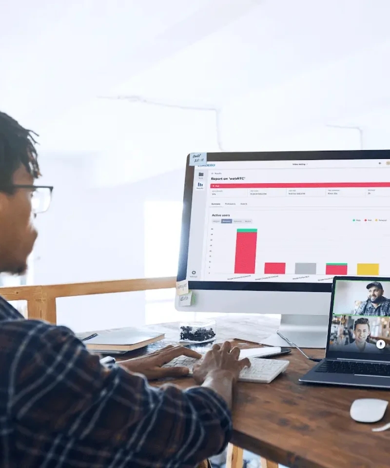 Un profesional trabajando en un escritorio con un gran gráfico mostrado en la pantalla, participando en una videollamada.