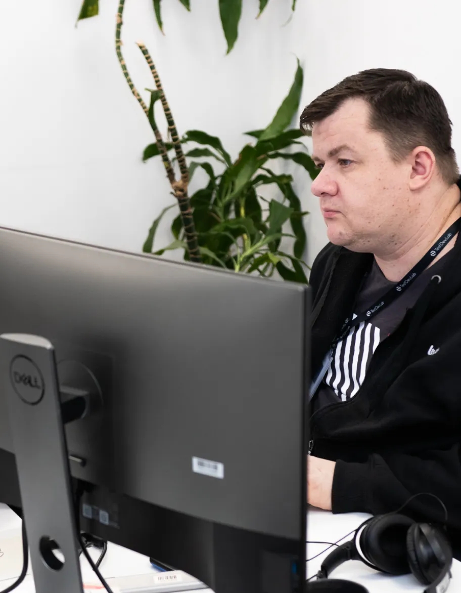 Network engineer sitting at the desk, working on a computer.