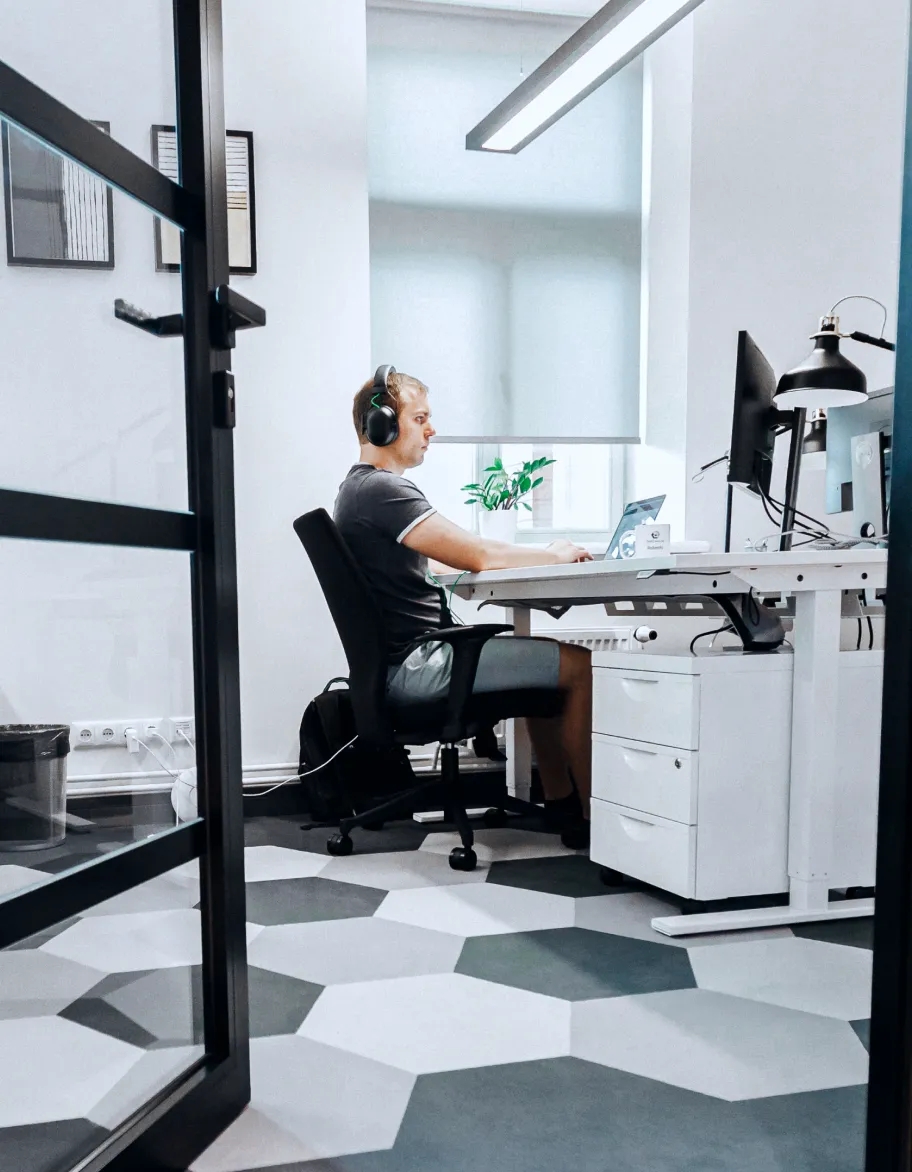 An office workspace with a QA engineer sitting at a desk and working.