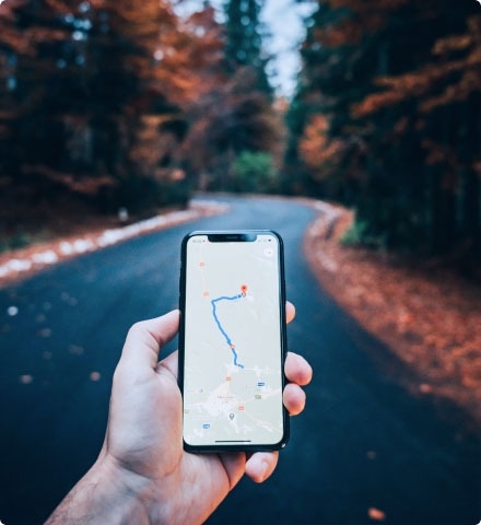 A person holding a mobile phone displaying a map.