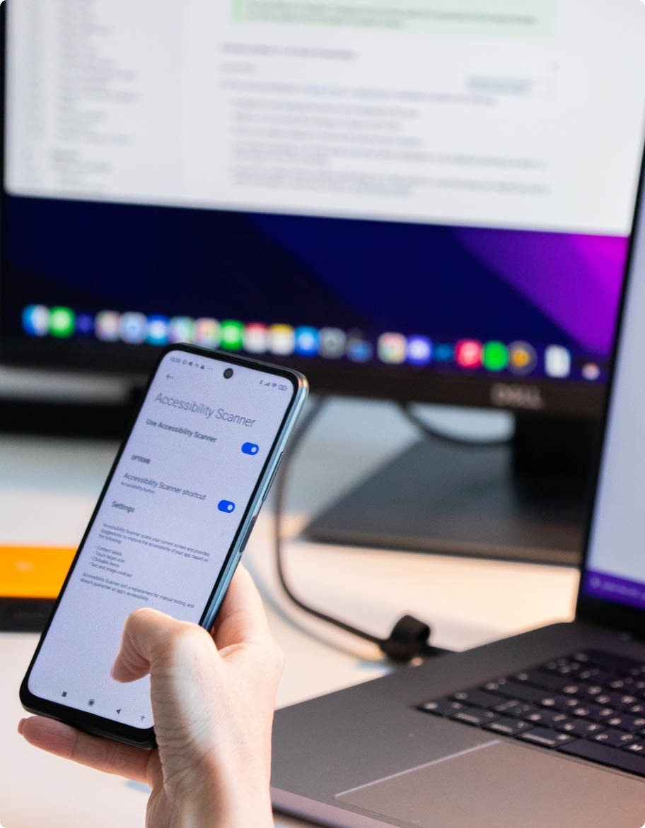 Software QA engineer using Accessibility Scanner tool on mobile phone.