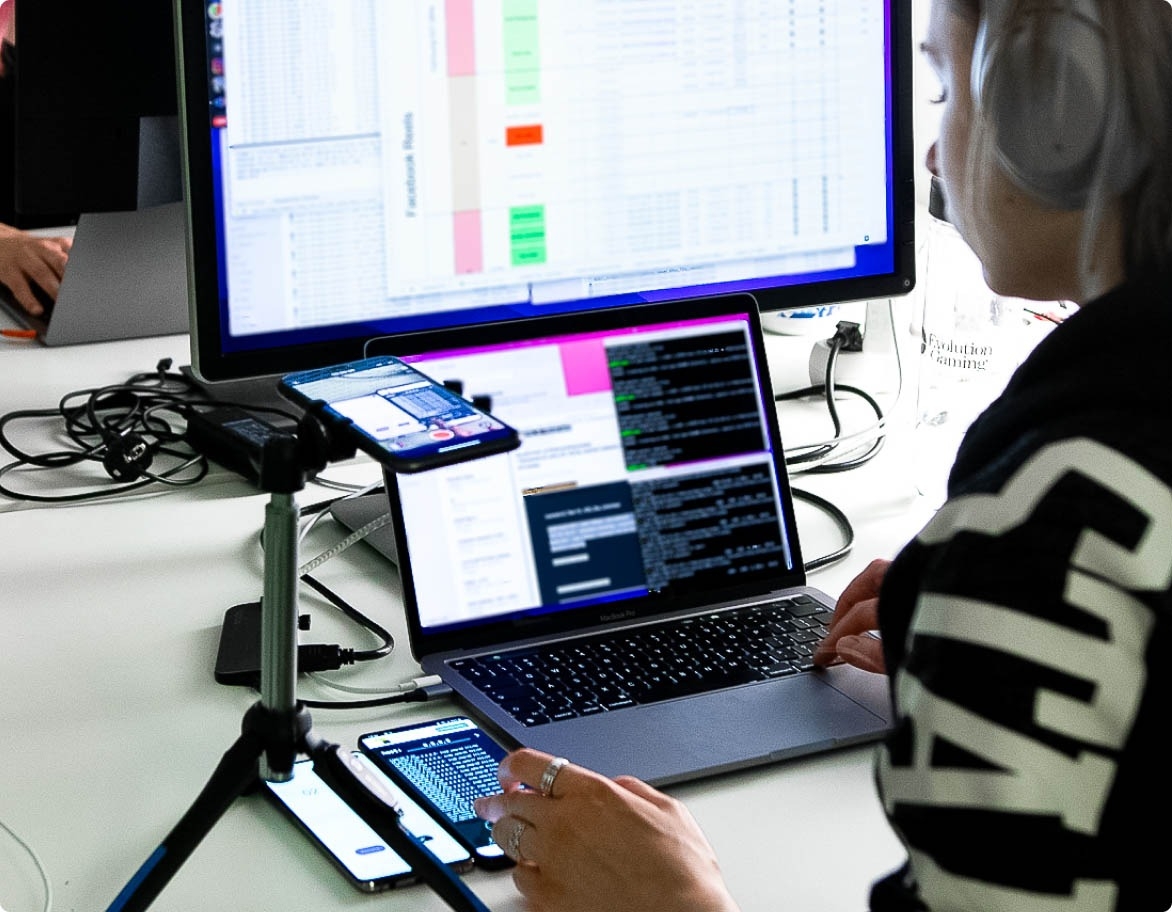 QA engineer working on a project with multiple devices on the table.