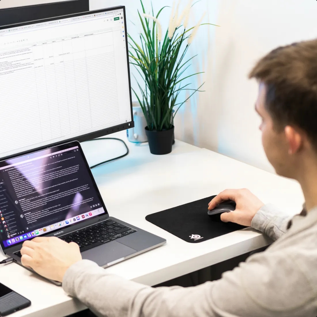 A QA engineer working on a project with a laptop.