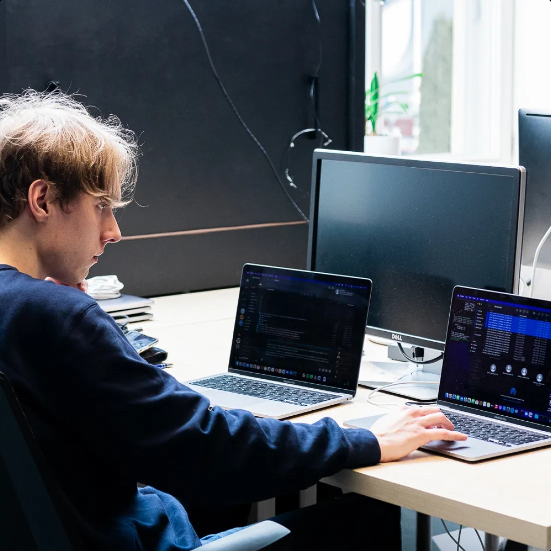 A QA engineer sitting at a desk and working on a laptop computer.