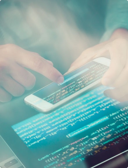 A QA engineer testing a security and authentication solution on a smartphone and tablet.