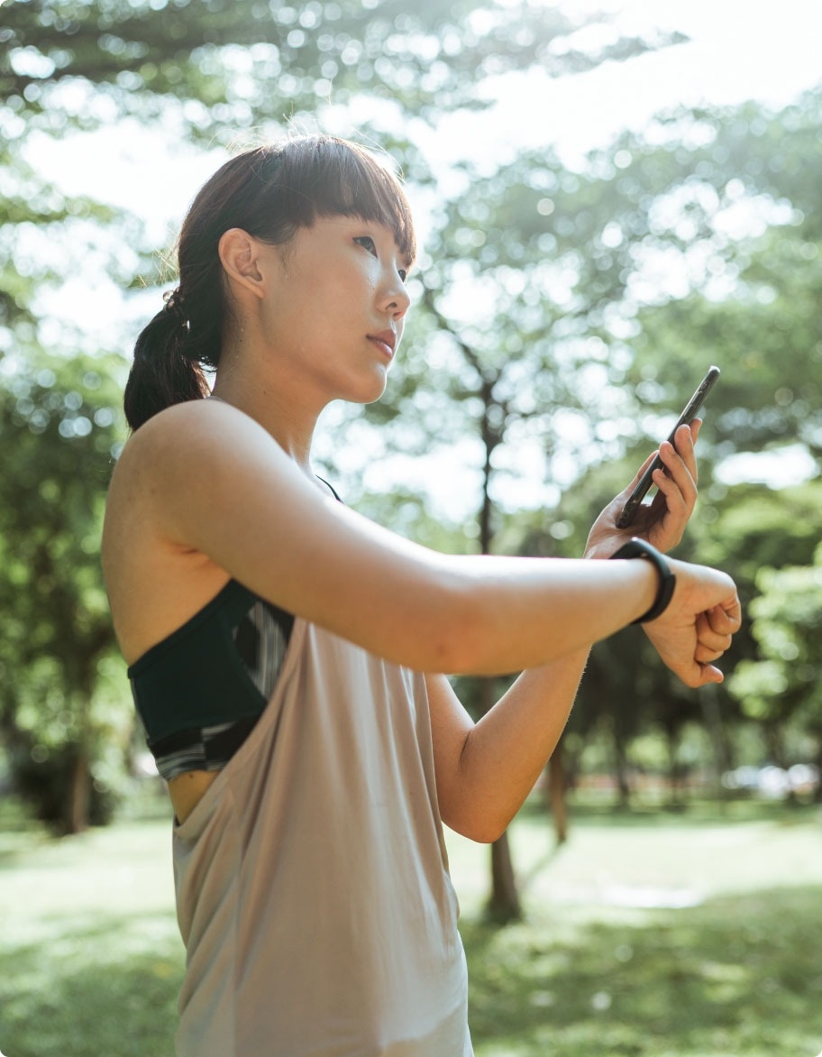 A woman using a healthcare solution on her mobile phone and smartwatch.