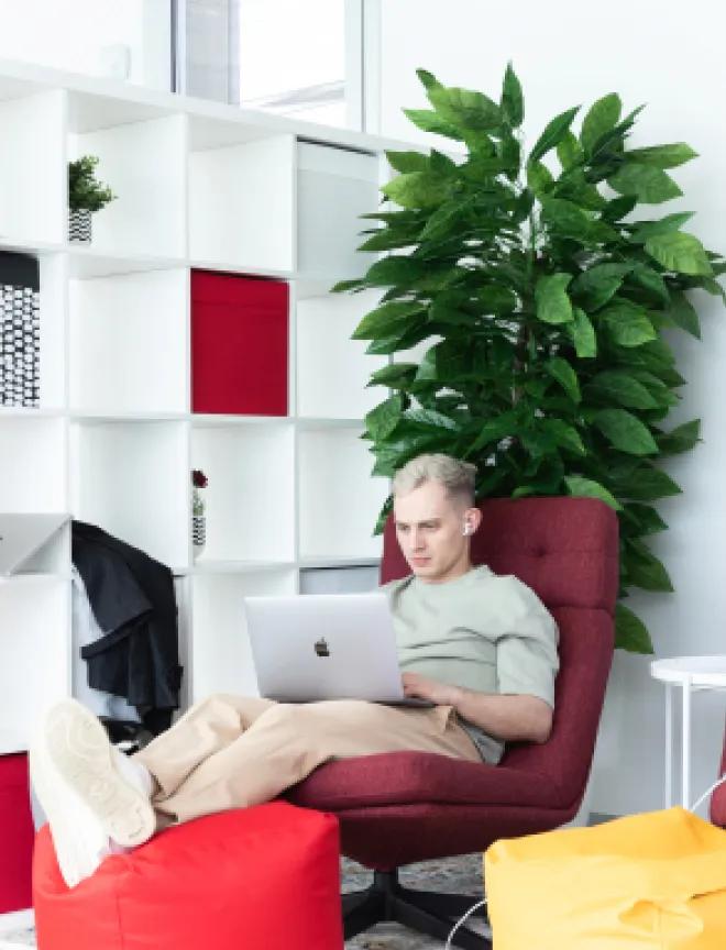 QA engineer laid back in the chair using a laptop.