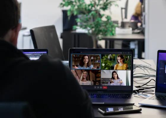 A QA engineer sitting at the desk, participating in a video call.