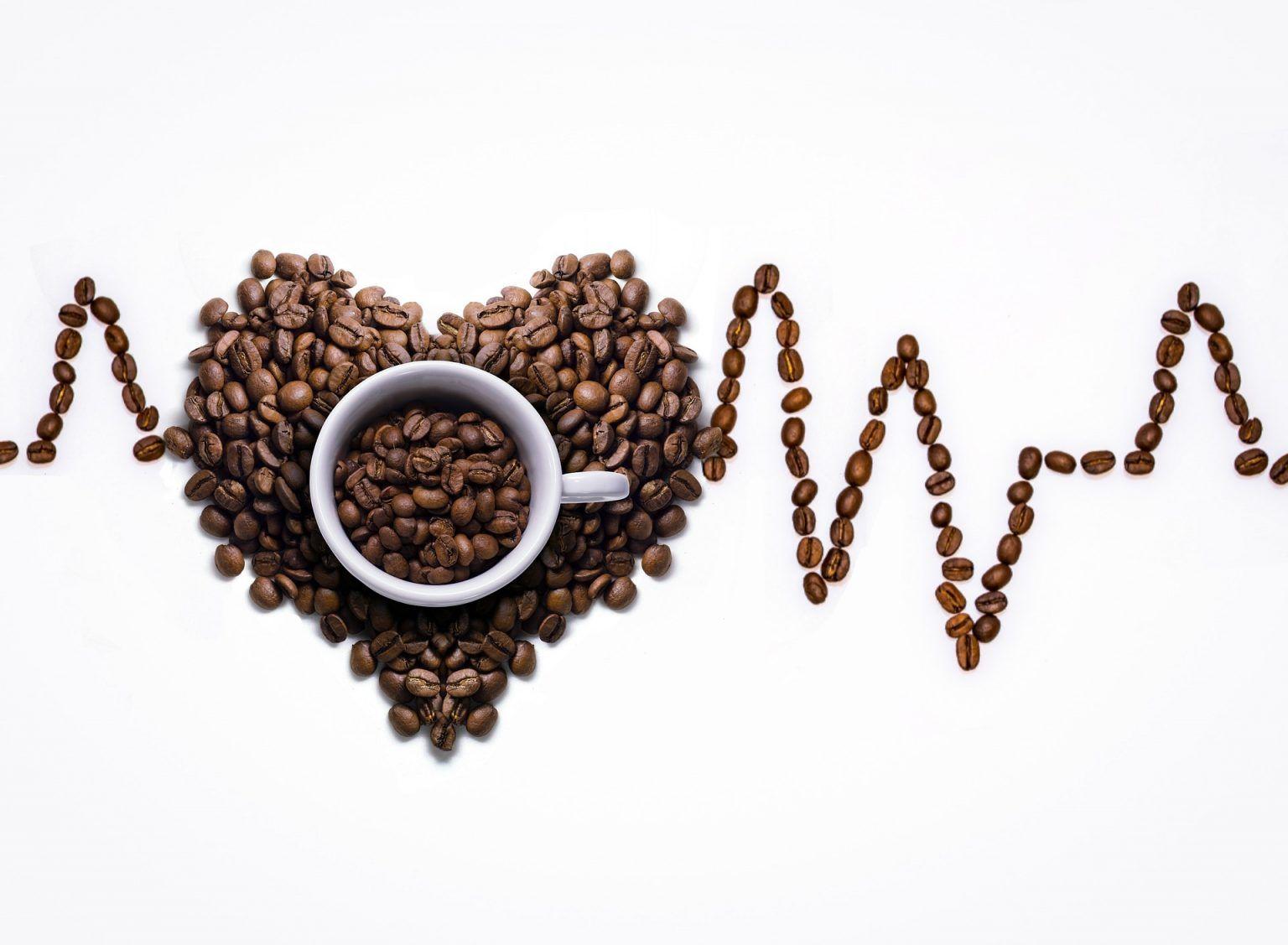 Coffee beans and a white cup filled with coffee beans