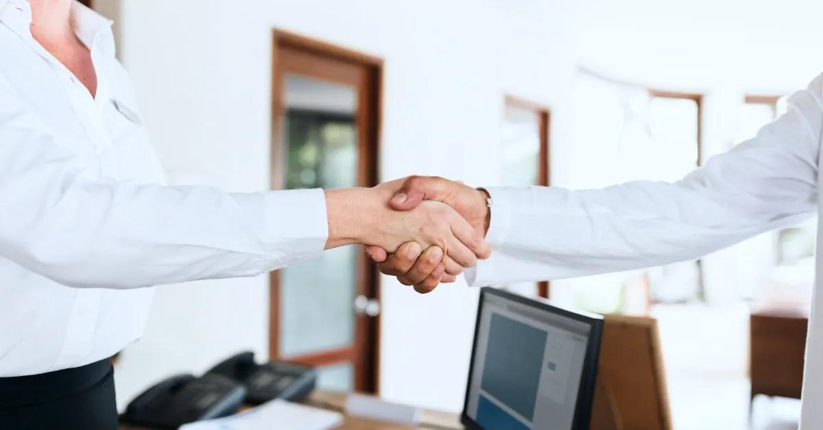 Two business associated shaking hands.