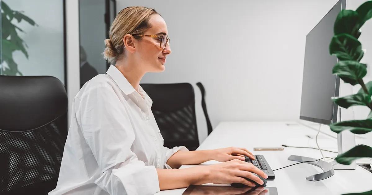 Woman working at a computer desk.