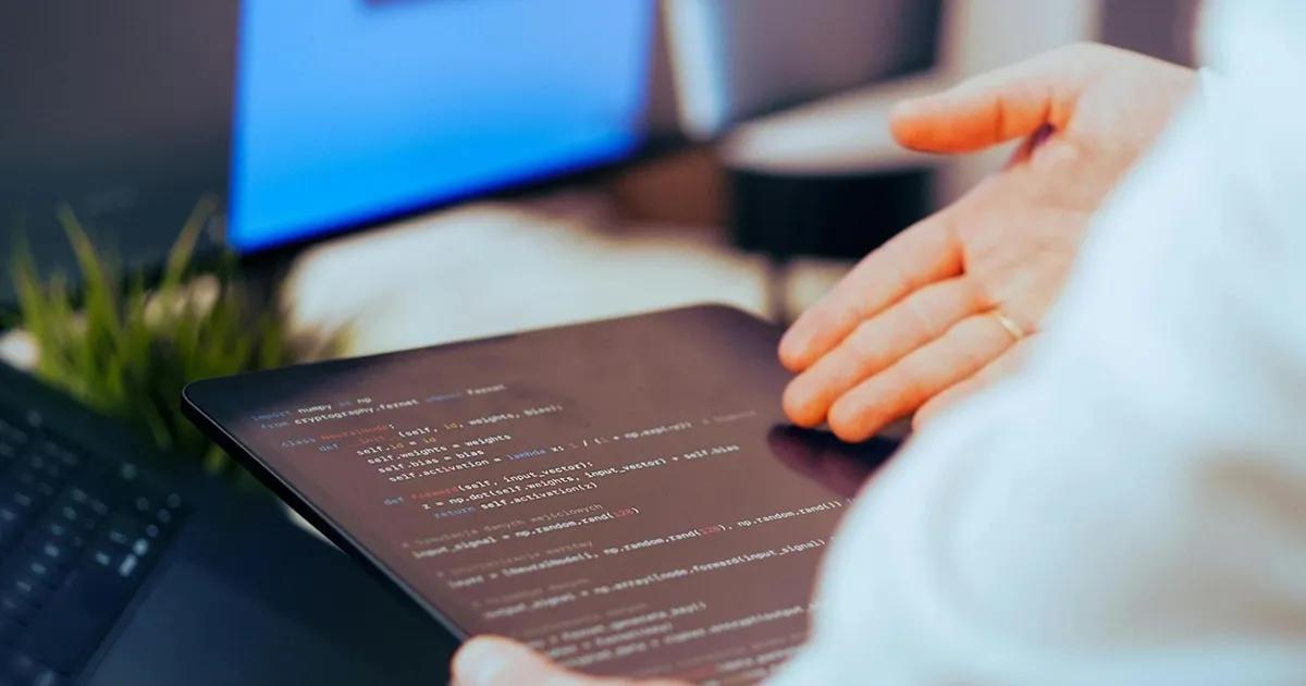 Hand gesturing to code displayed on a tablet