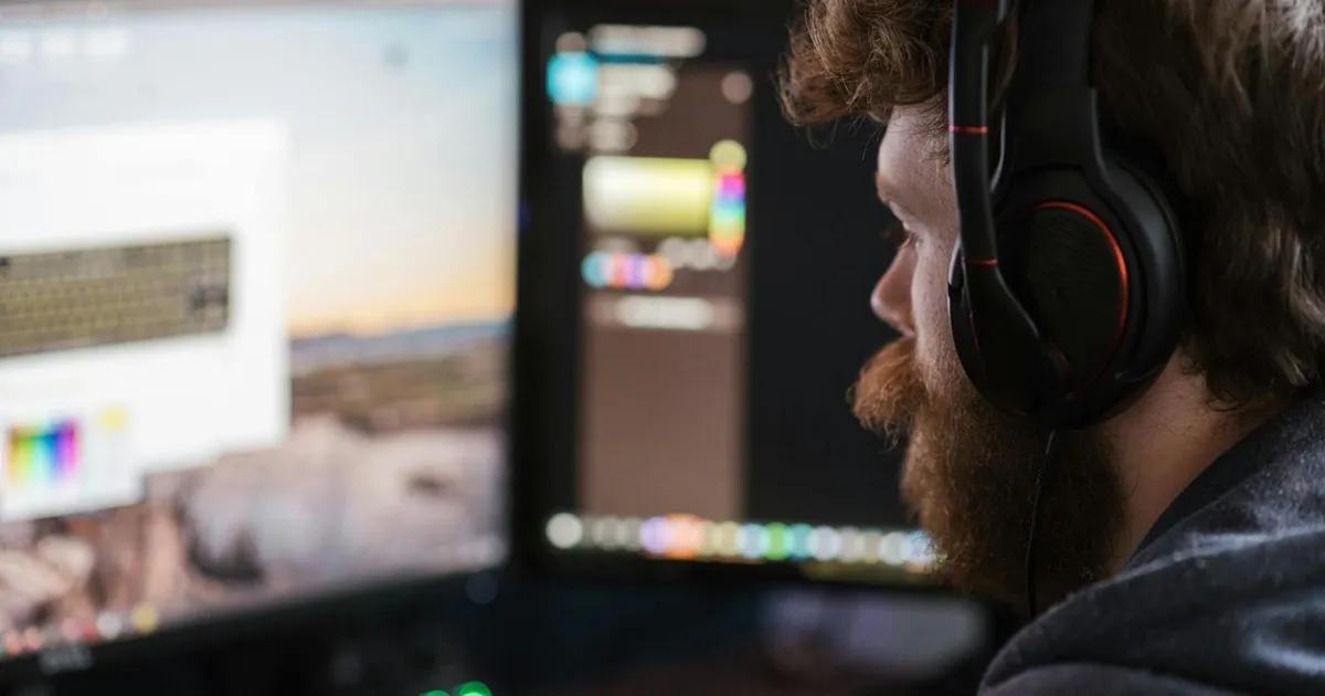 QA engineer wearing headphones looking at computer screen