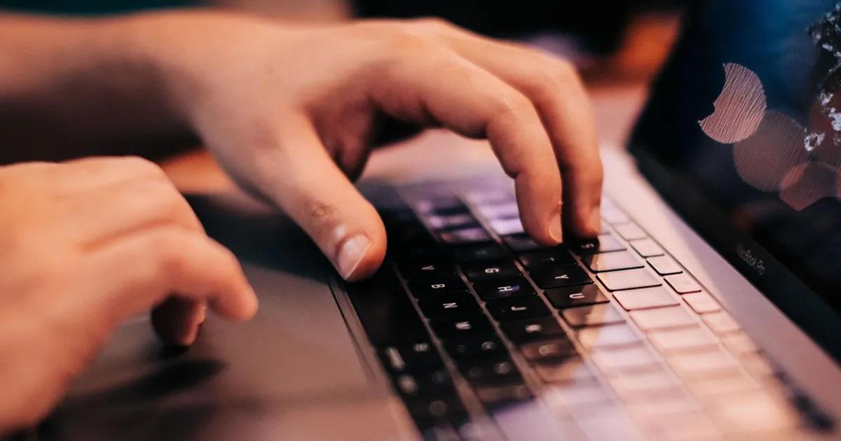 Closeup of hand on laptop touchpad and keyboard