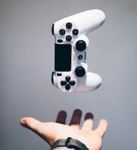 A person catching white PS4 controller.