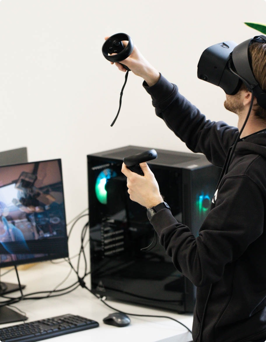 QA inženieris ar VR brillēm un ar VR kontrolleriem abās rokās, testējot PR/VR risinājumu.