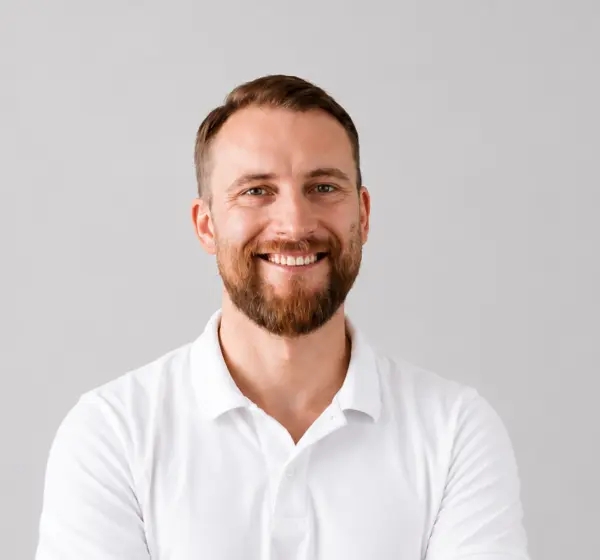 Retrato de un hombre sonriente con barba.
