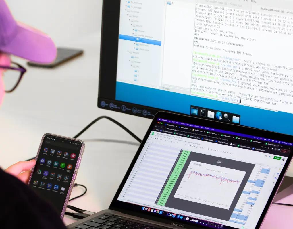 Tester comparing results across a phone, laptop, and monitor