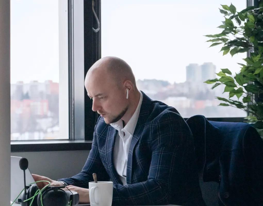 Engineer focused on a laptop by an office window