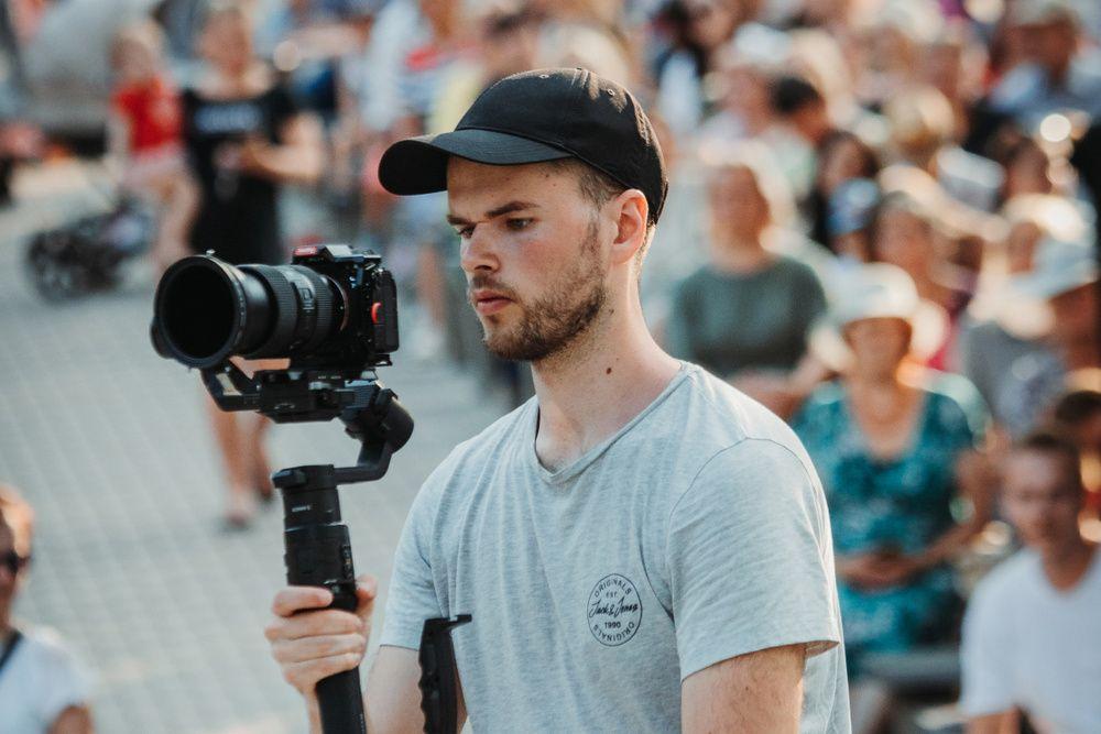 TestDevLab employee holding a camera and looking at screen