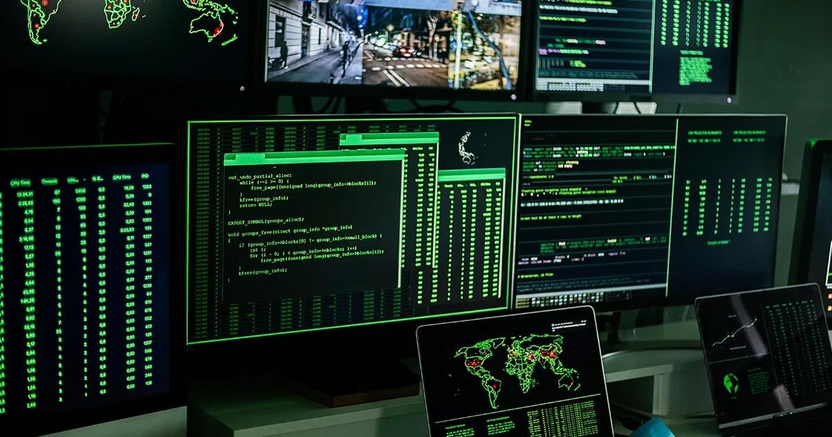 Multiple computer screens on display in dark space