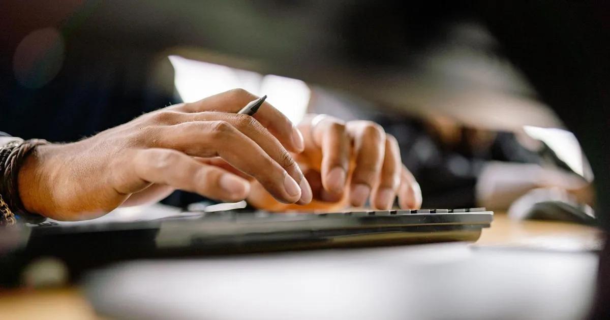 Close-up of hands typing on keyboard