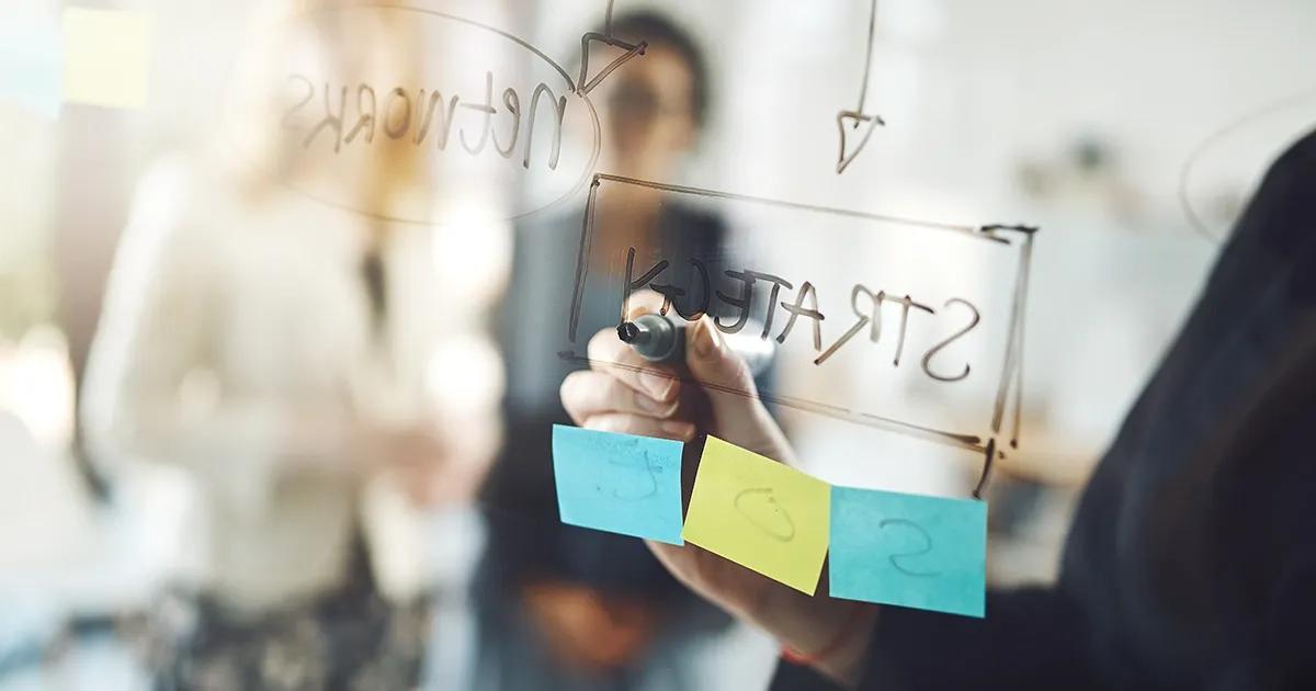 Person writing on a transparent board with a marker